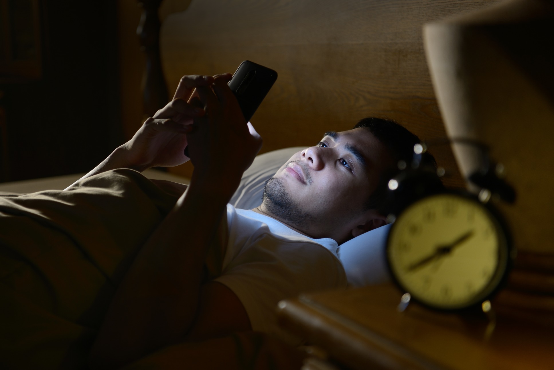 young-man-using-a-smartphone-in-his-bed-at-night-P88RXTS (1)